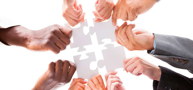 l'immagine mostra 4 mani che uniscono dei pezzi di puzzle